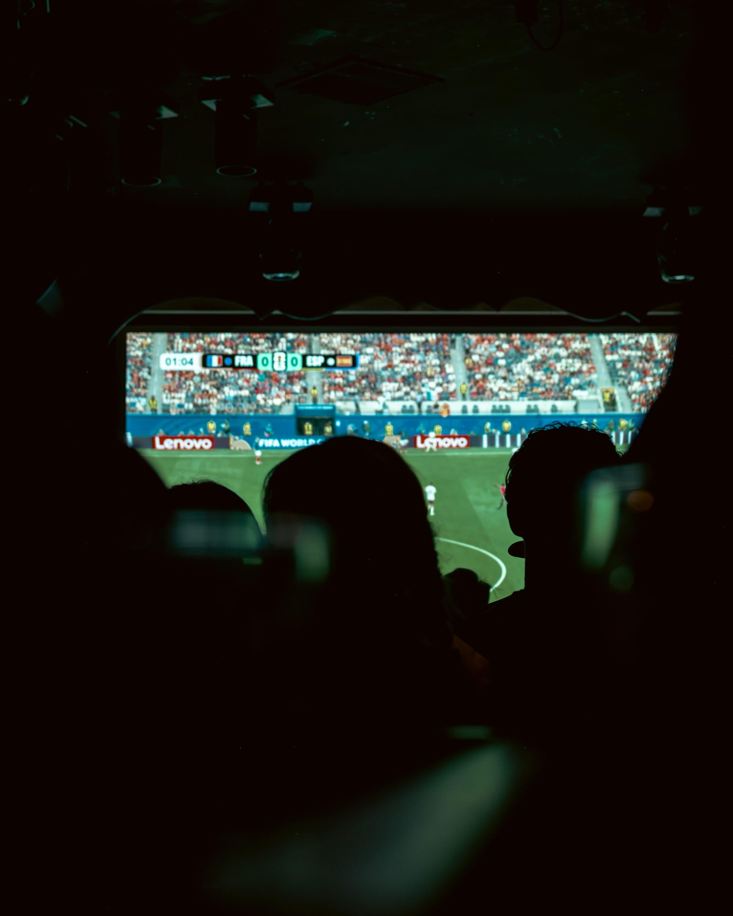 Screen glow catching the crowd's silhouette, scoreboard reading France nil, Spain nil