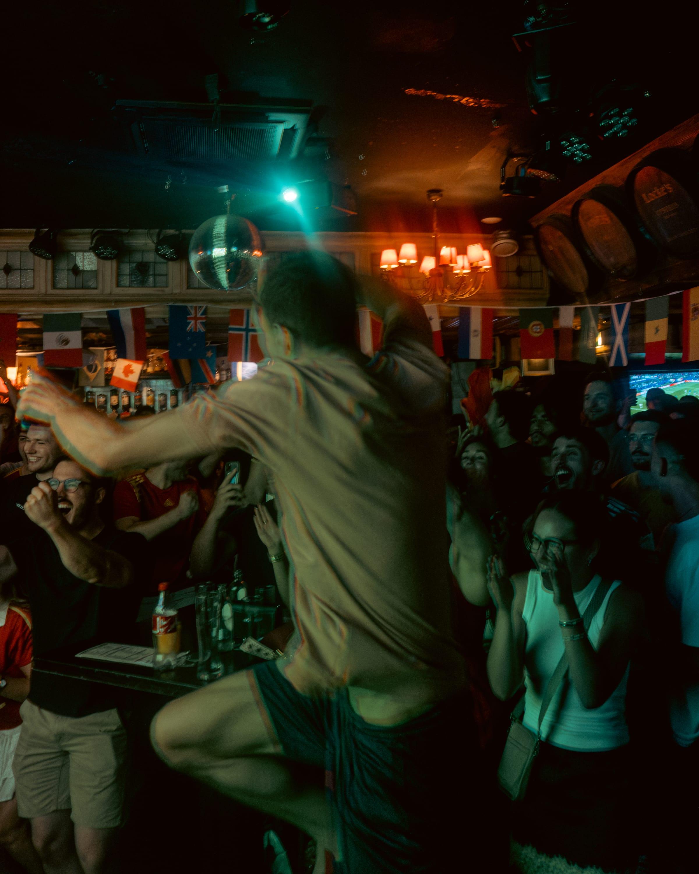 A fan leaps under the disco ball as the room erupts behind him