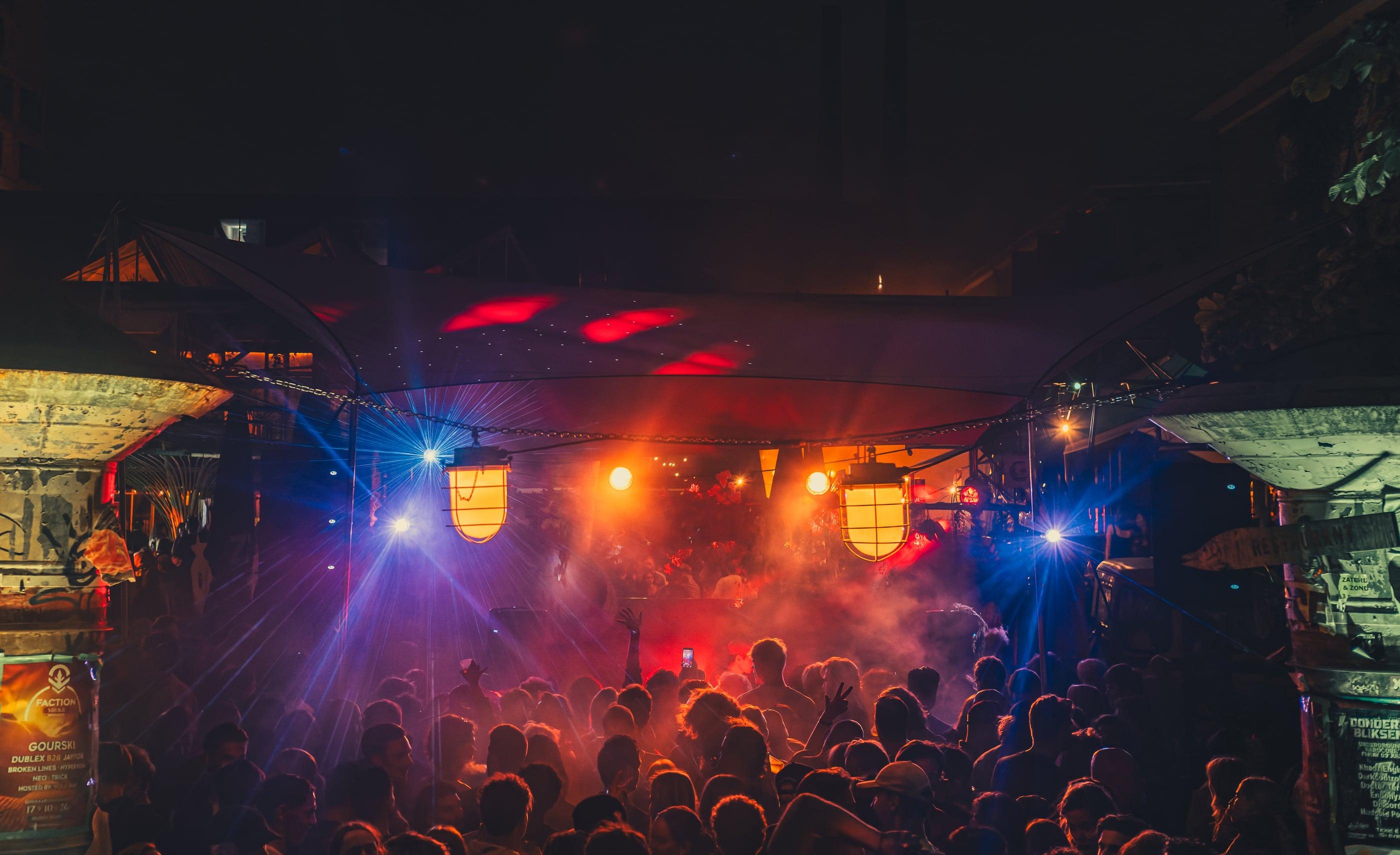 A band performing on stage under coloured stage light