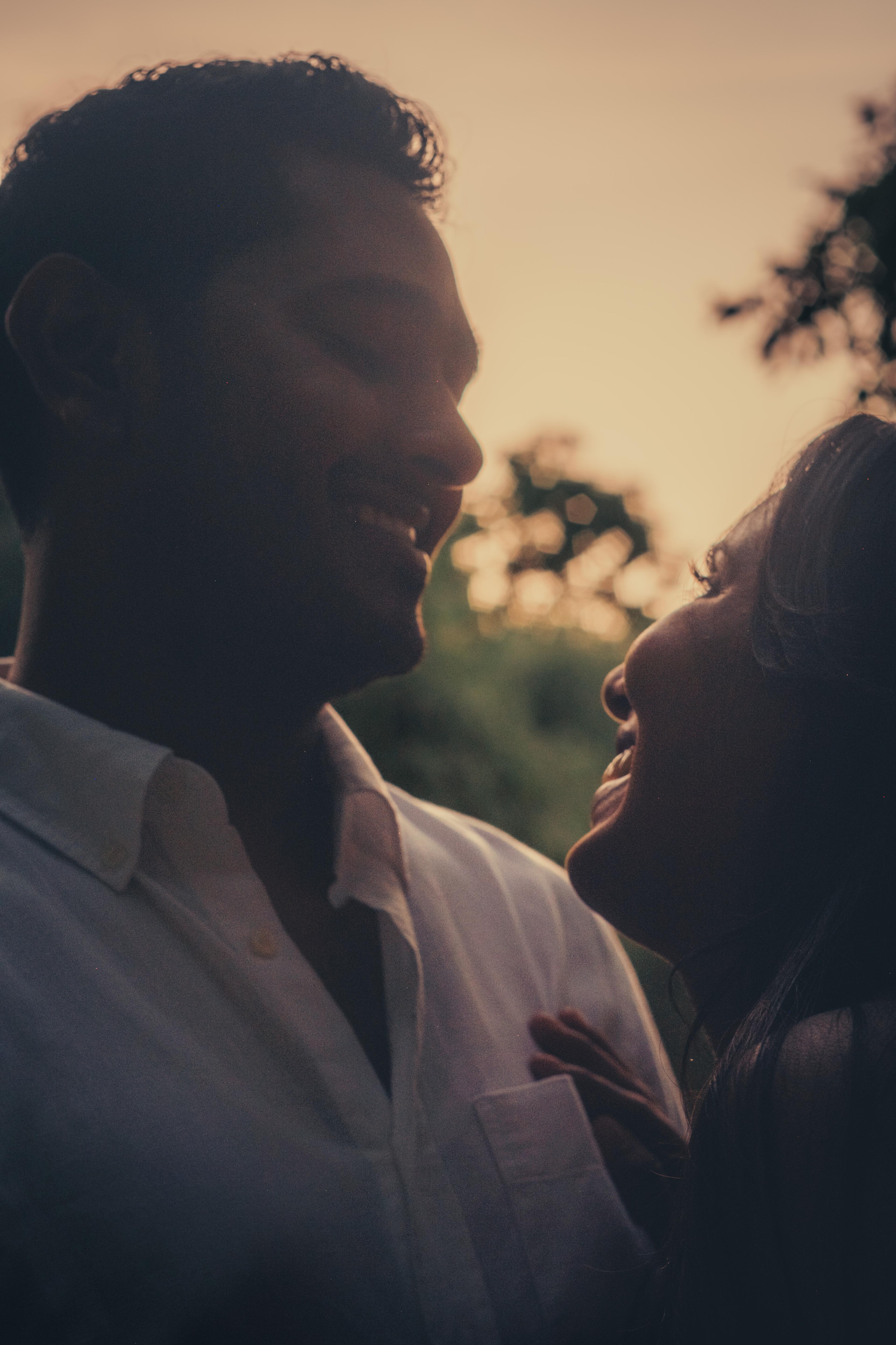 Couple's faces close together at golden hour, foreheads nearly touching