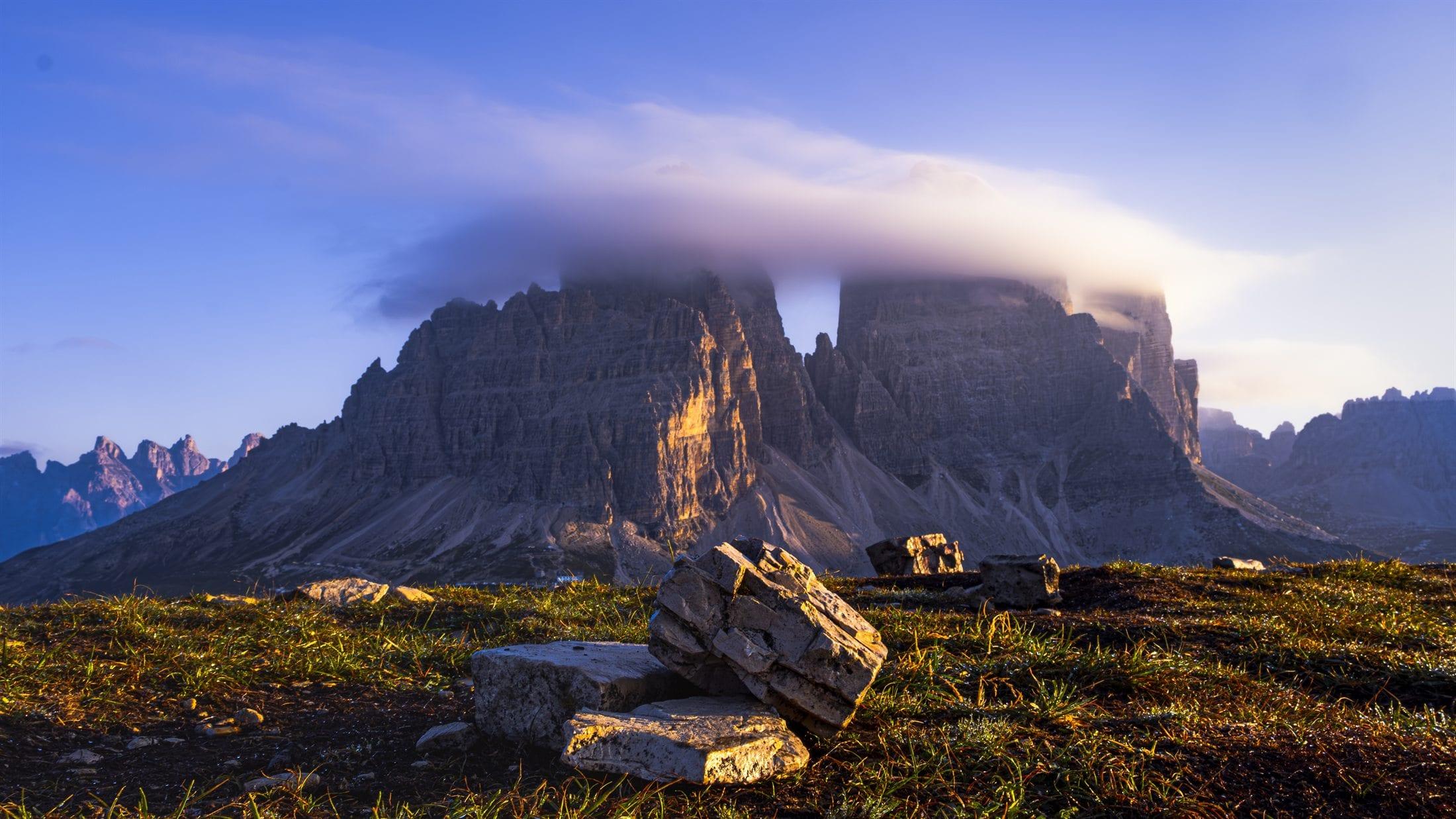 Ridge line lit gold at sunset with cloud resting on the summit