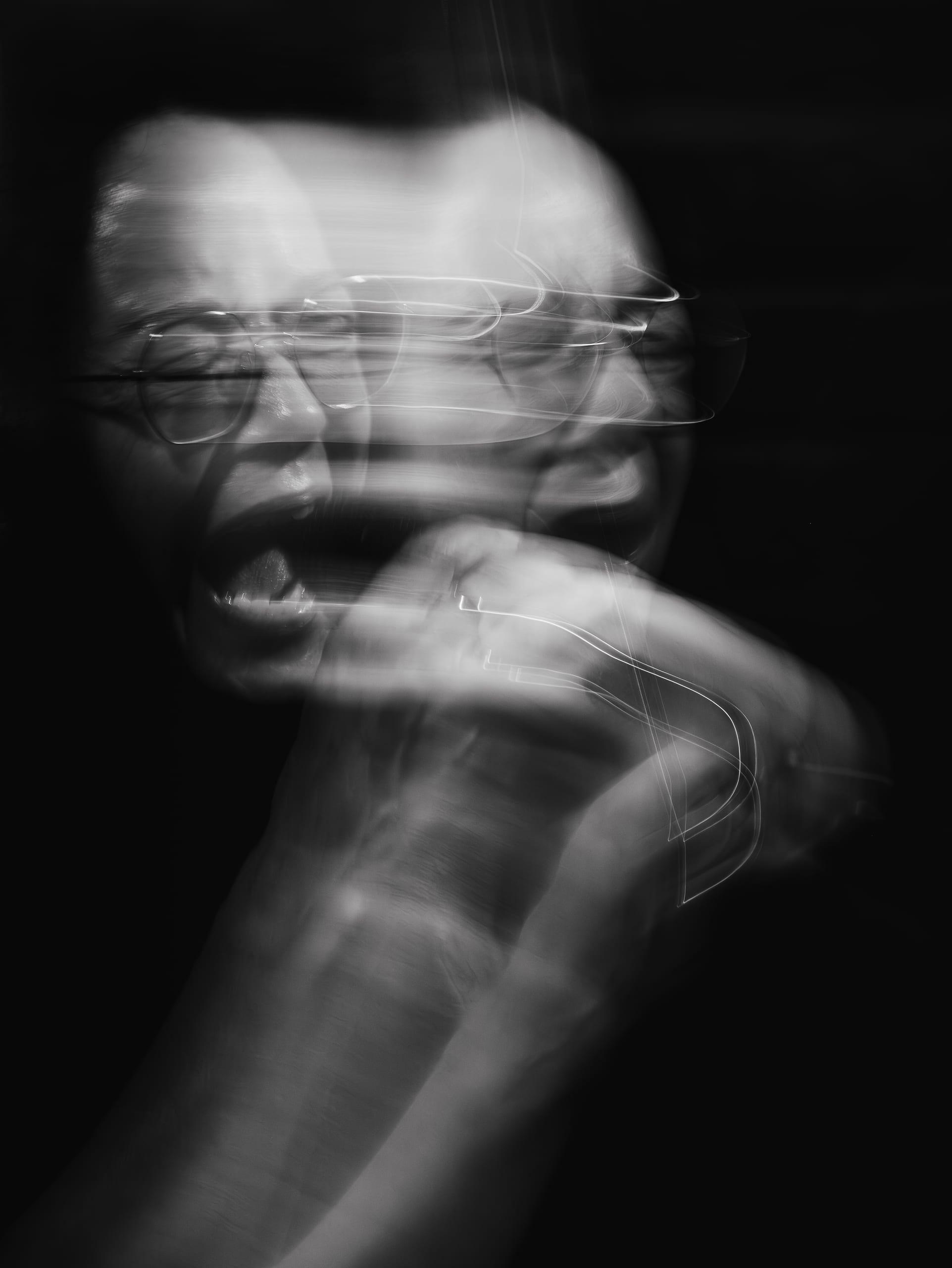 Long exposure of a singer mid-shout, features blurred with motion