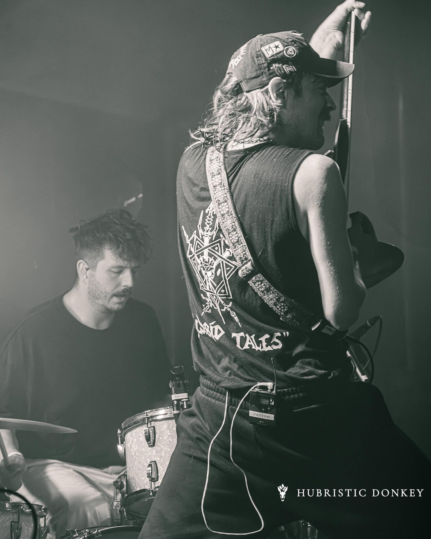 A guitarist mid-performance on stage at Breda Barst, black and white